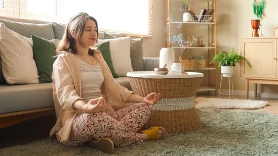 Kobieta praktykująca spokojny oddech i relaks w domu, naturalne sposoby obniżania poziomu kortyzolu i redukcji stresu